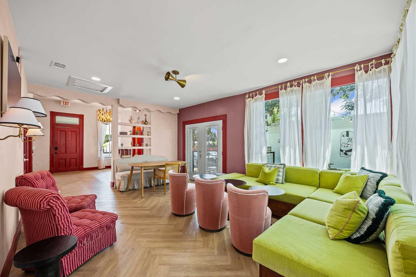 Commercial interior in North East Austin with a green sofa, pink armchairs and tall windows