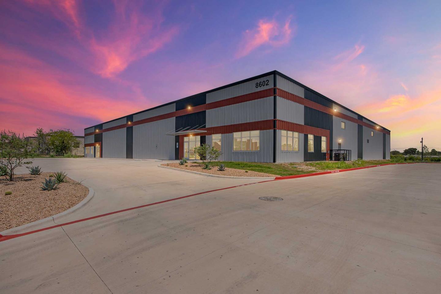 Flex industrial building in East Austin photographed at dusk under a pink and blue sky