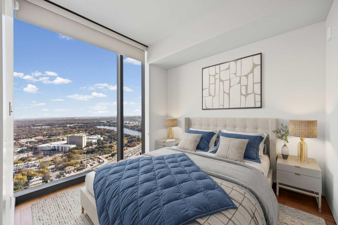 Downtown condo bedroom with a low bed and a window wall looking out over the skyline