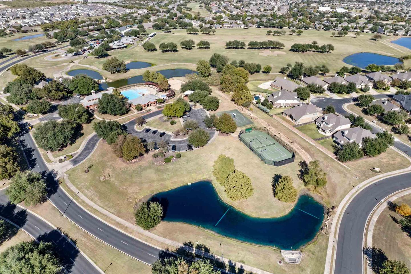 Aerial view of an Austin neighborhood built around a landscaped lake and walking paths
