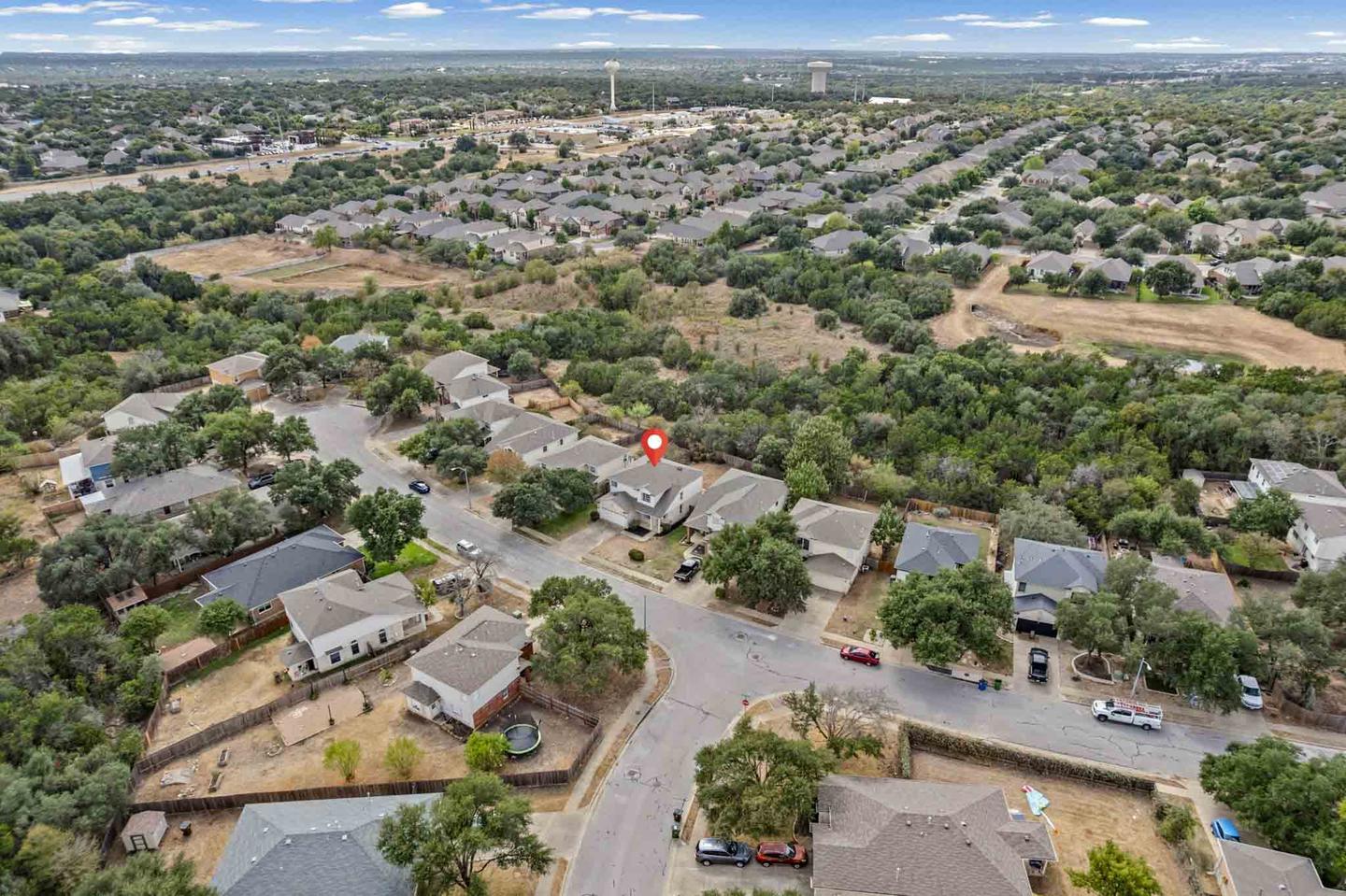 Aerial photograph of a Round Rock neighborhood with a single lot pinned and highlighted