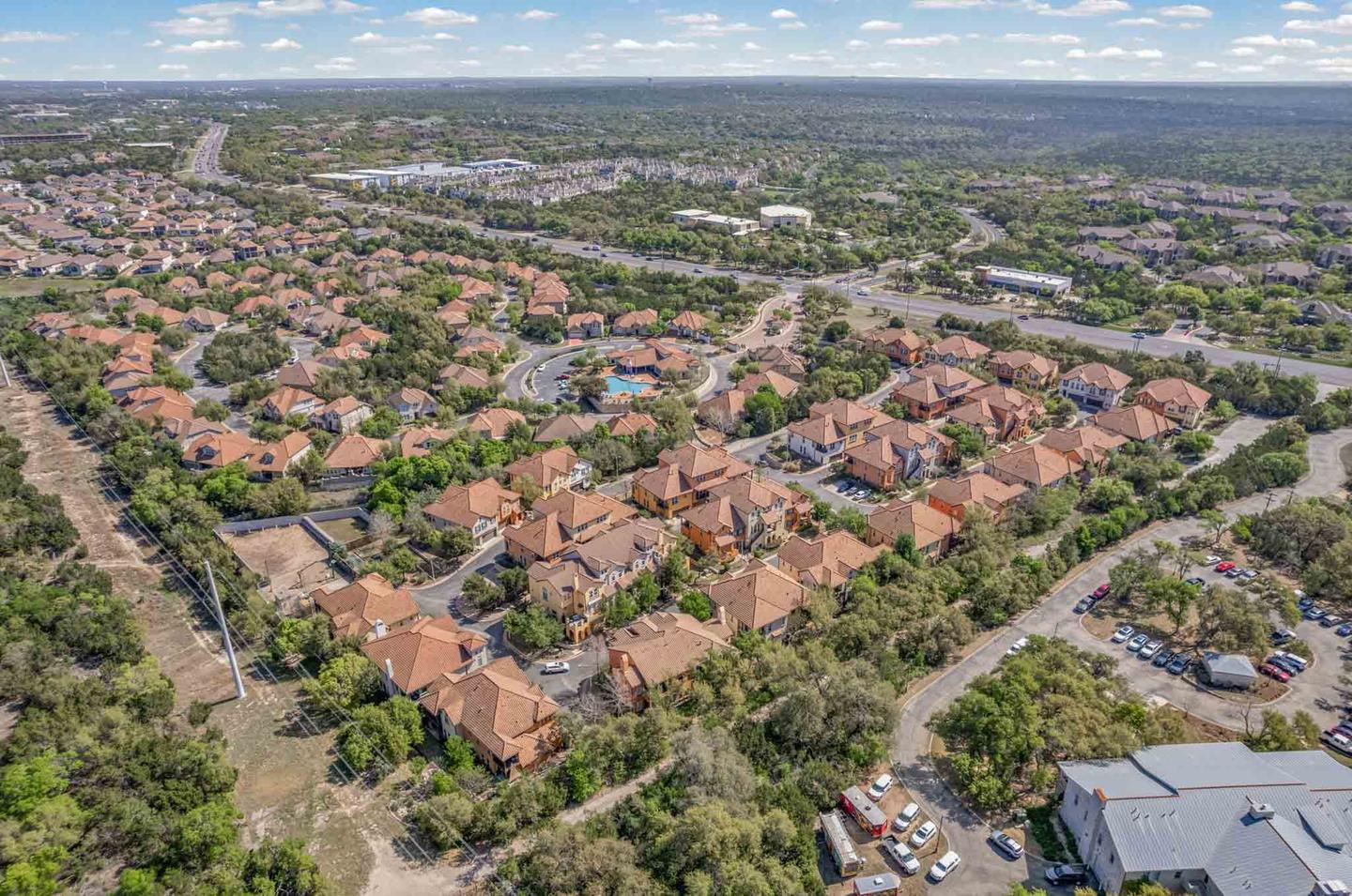 Aerial view of a Georgetown subdivision with mature street trees and stone fronted homes