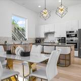 Open plan Westlake kitchen and dining area with pendant lighting and a stone island