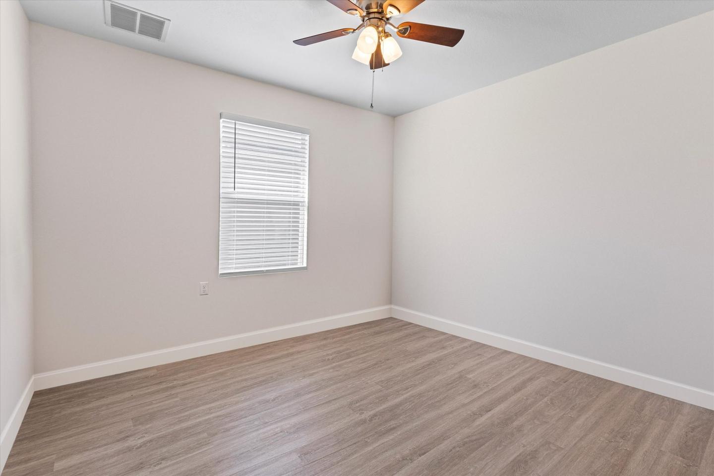 The same bedroom cleared to bare walls and floor, ready to photograph
