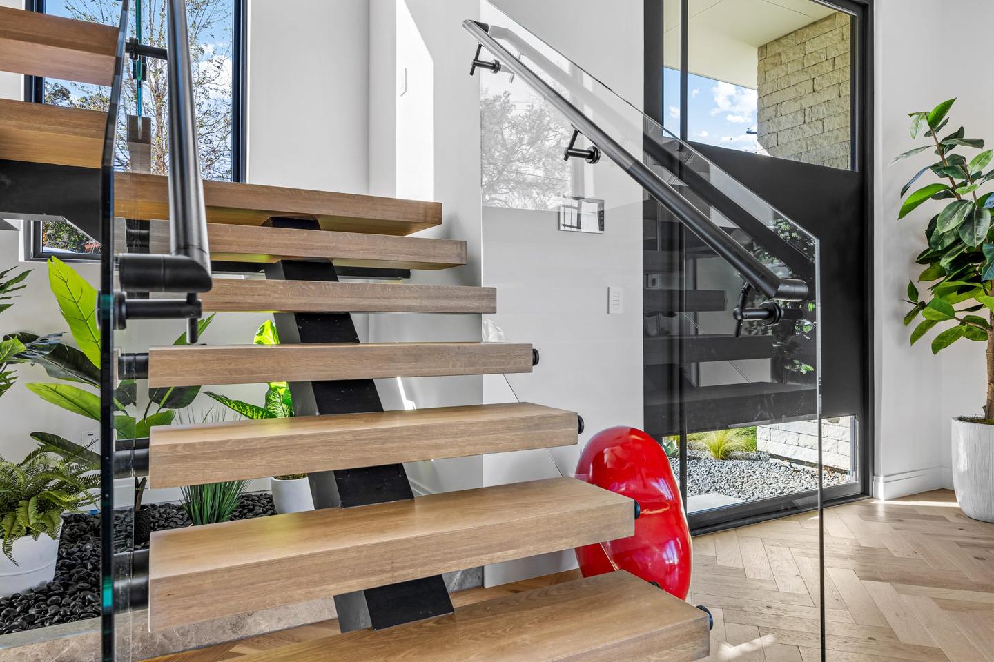 Open tread timber staircase with a steel stringer rising through a double height entry