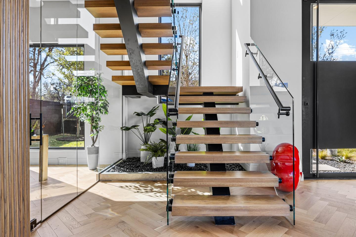 Double height entry hall looking up the open tread stair toward the first floor