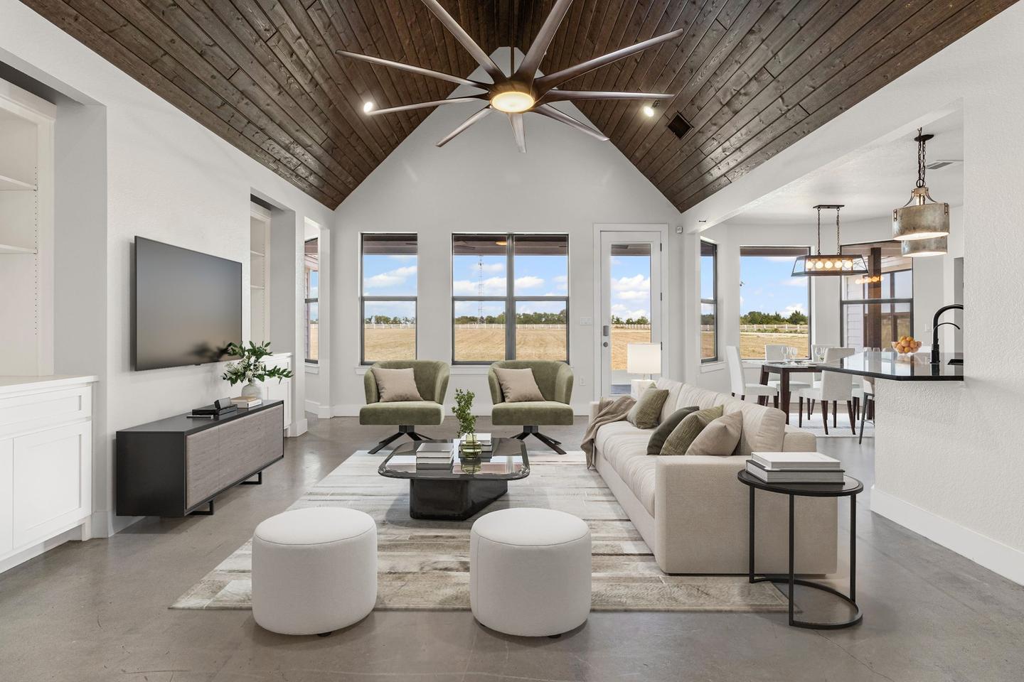 Great room with a timber clad vaulted ceiling, furnished digitally with pale seating and a long rug