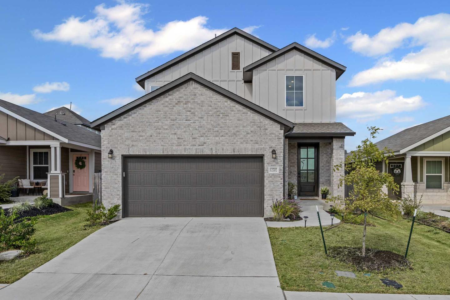 Single story stone and brick home in Buda photographed from the driveway