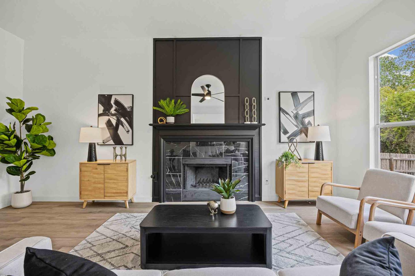 Living room with a stone fireplace, arched built in shelving and a pair of armchairs