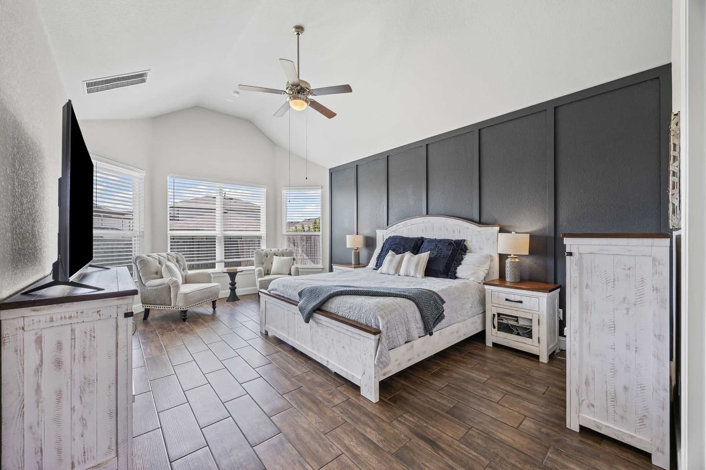 Primary bedroom in a Georgetown home with a tray ceiling and upholstered headboard