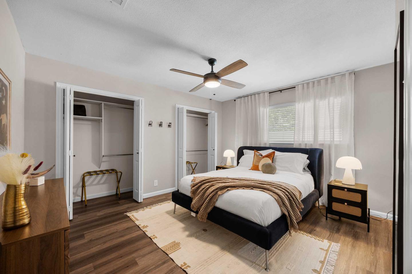 Short term rental bedroom in Cedar Park with a dark bed frame and a mirrored closet