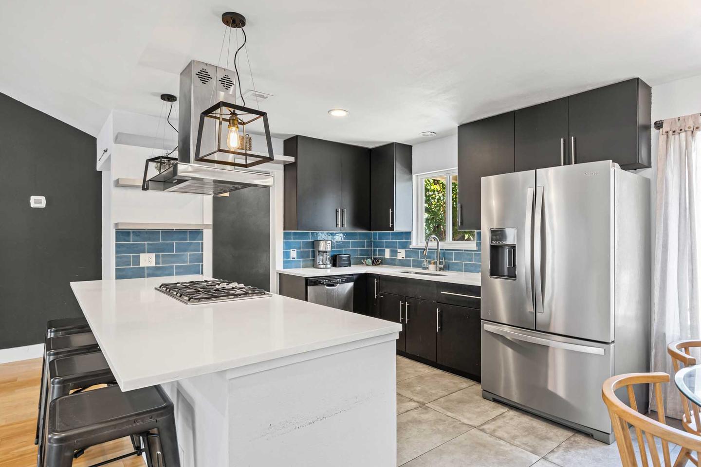 Short term rental kitchen in East Austin with a blue tile splashback and a white island