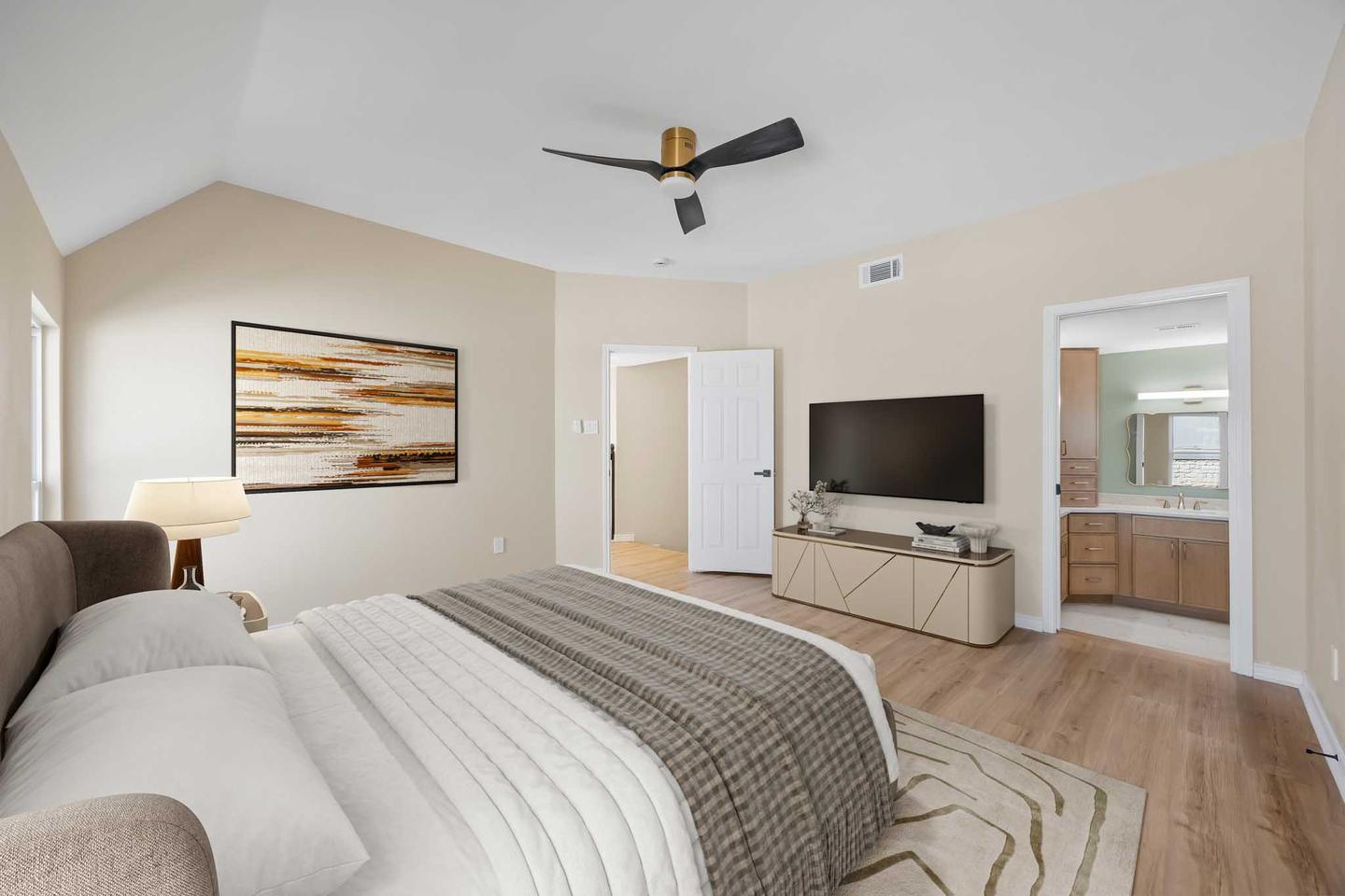 Bedroom digitally staged with a low bed, bedside lamps and framed art over the headboard